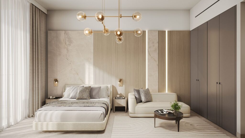 Une chambre moderne aux tons neutres, idéale pour ceux qui souhaitent investir dans un studio à Dubaï, comprenant un grand lit, un canapé beige, des armoires encastrées, une décoration minimaliste, une table basse ronde, de grandes fenêtres ornées de voilages et un lustre contemporain doré.