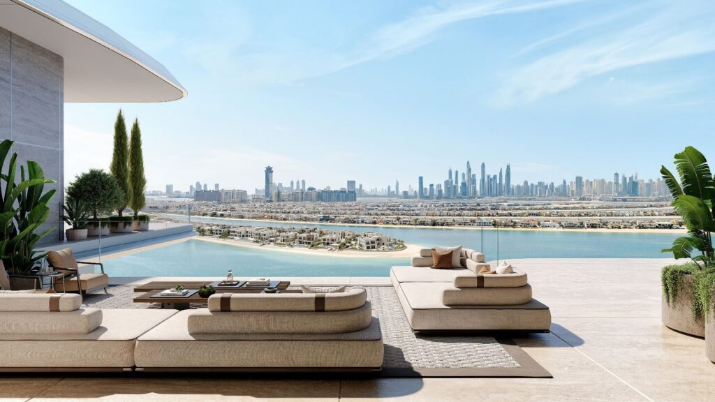 Une luxueuse terrasse extérieure avec des canapés modernes surplombe un lagon, des îles en forme de palmiers et la ligne d'horizon de la ville de Dubaï. Des plantes luxuriantes et une piscine à débordement complètent ce cadre serein, qui incarne l'élégance du Marché immobilier de Dubaï.