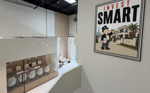 Intérieur de bureau moderne, avec en contrebas une salle de réunion aux parois vitrées et une grande affiche murale représentant la mascotte du Monopoly et portant l'inscription « Invest Smart », à côté d'une illustration de villas haut de gamme — une source d'inspiration idéale pour les investisseurs des bureaux de Dubai Immo à Dubaï.