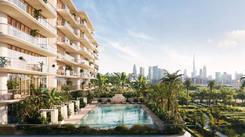 « Le Château Piétrus », un immeuble d'appartements moderne doté de balcons, surplombe une piscine entourée de palmiers et de verdure, avec en arrière-plan la silhouette de la ville — dont un grand gratte-ciel — sous un ciel dégagé.