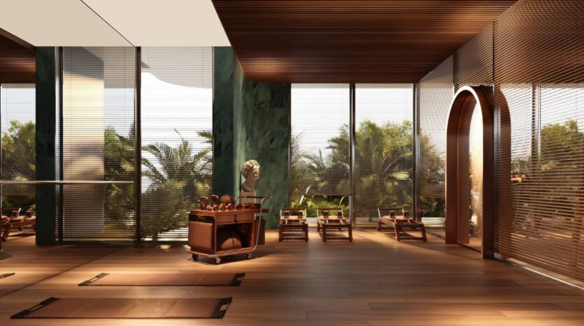 Un studio de yoga moderne et baigné de lumière, avec un parquet, de grandes baies vitrées donnant sur des palmiers, des tapis de yoga posés à même le sol, des chaises en bois et une statue posée sur une table en bois — un lieu qui dégage une élégance sereine rappelant Le Château Piétrus.