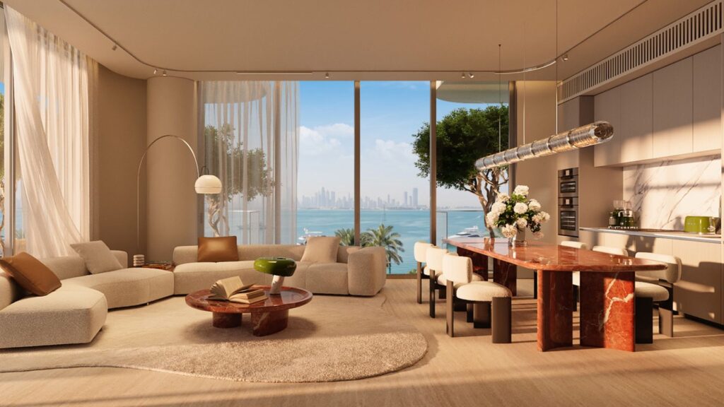 Un salon et une salle à manger contemporains dotés de grandes baies vitrées offrant une vue sur les toits de la ville et sur l'eau, avec un mobilier aux tons neutres, une table à manger en marbre rouge qui rappelle l'élégance du Château Piétrus, des plantes vertes et une lumière naturelle abondante.