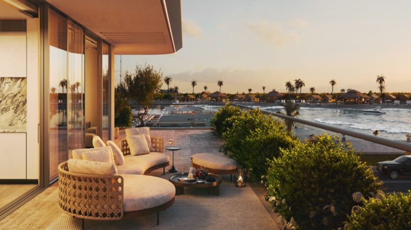Une terrasse luxueuse, agrémentée d'un coin salon extérieur raffiné, donne sur l'eau, les palmiers et les bateaux au coucher du soleil, créant ainsi une atmosphère paisible et chic qui rappelle les soirées au Château Piétrus.