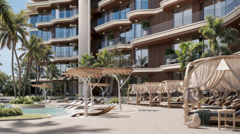 Espace piscine d'un hôtel de luxe, avec des chaises longues modernes, des cabanes ombragées, des palmiers et des balcons incurvés, le tout avec en arrière-plan un immeuble de plusieurs étages. Inspirée par la sérénité de la lagune Mirari de Zoya, cette scène dégage une atmosphère ensoleillée et tropicale.