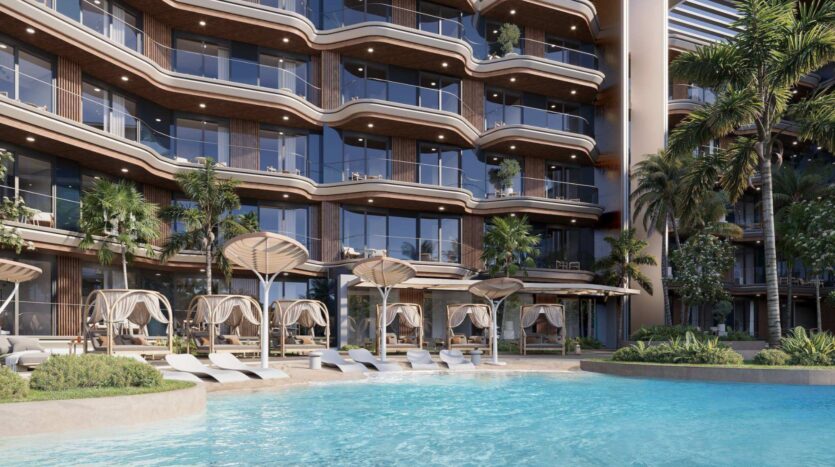 L'hôtel de luxe contemporain « Mirari Lagoon by Zoya », doté de balcons vitrés, donne sur une piscine aux eaux bleues cristallines, des transats partiellement immergés dans l'eau, des cabanes ombragées et des palmiers luxuriants, créant ainsi une ambiance tropicale et relaxante.