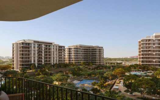 Vue depuis un balcon donnant sur les immeubles d'appartements modernes du complexe « The Canopies by Aldar », entourés d'arbres, d'une piscine et de terrains de sport, sous un ciel bleu limpide.