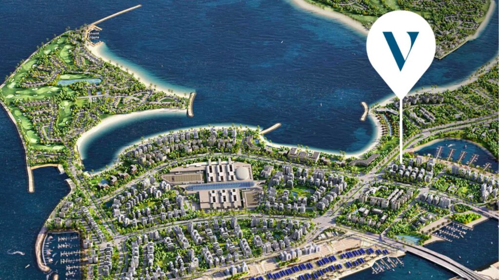 Illustration aérienne d'une ville côtière avec des bâtiments, des espaces verts, des ports de plaisance et un vaste front de mer. Une épingle de carte portant un « V » bleu indique l'emplacement de Vue Dorée près du littoral.